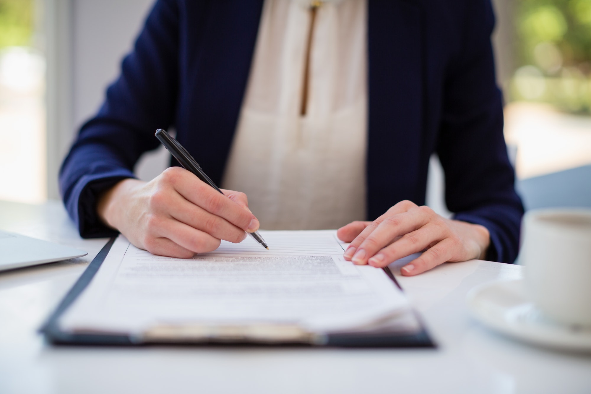 Businesswoman writing on clipboard